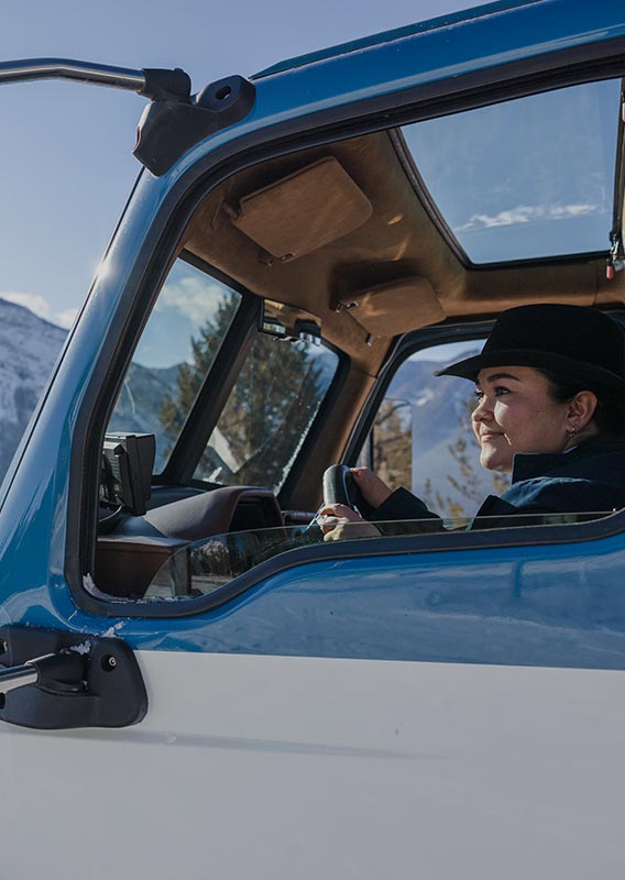 A driver in a vintage style touring automobile.